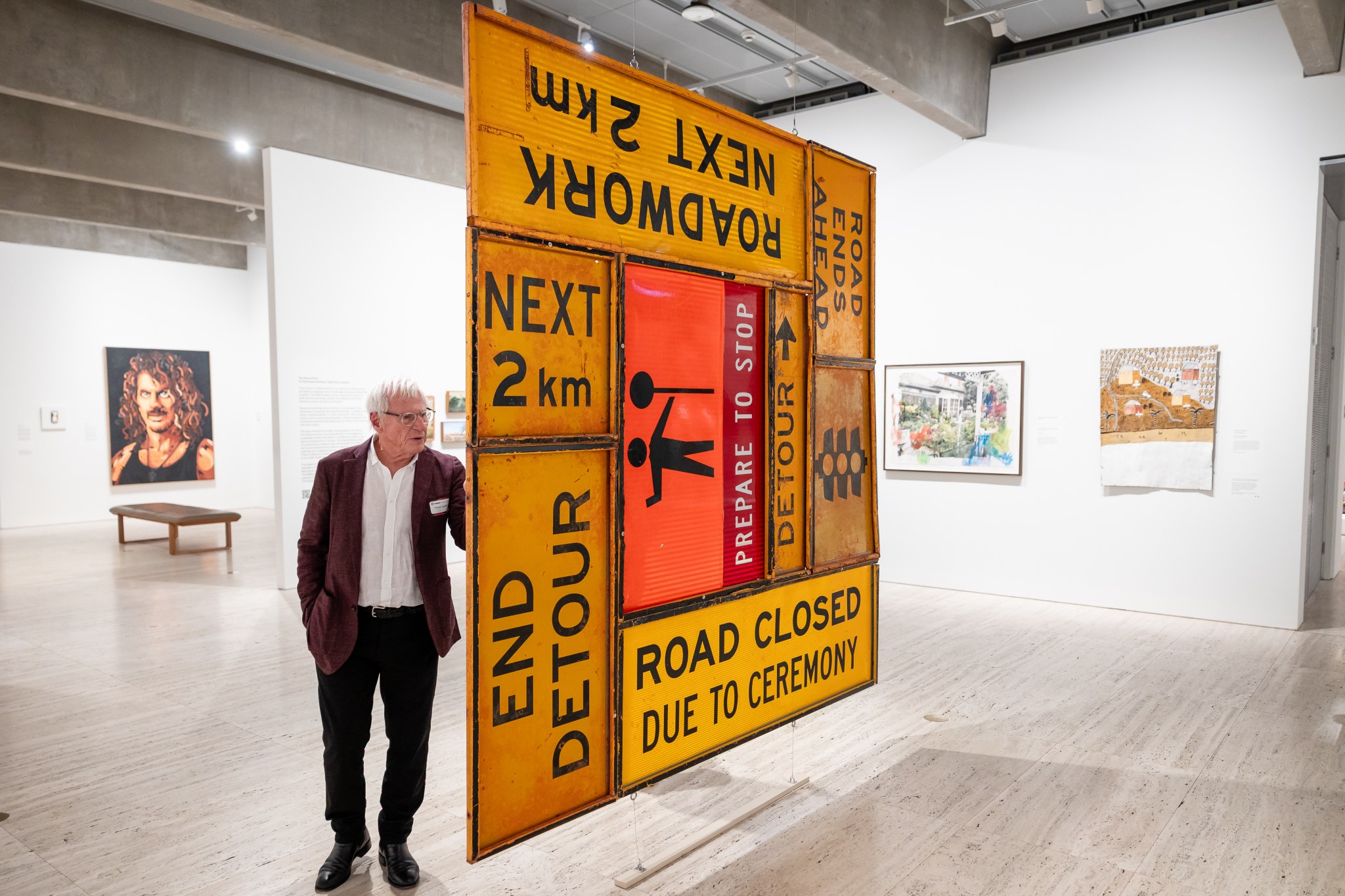 Guest viewing an artwork assembled from yellow and orange road signs