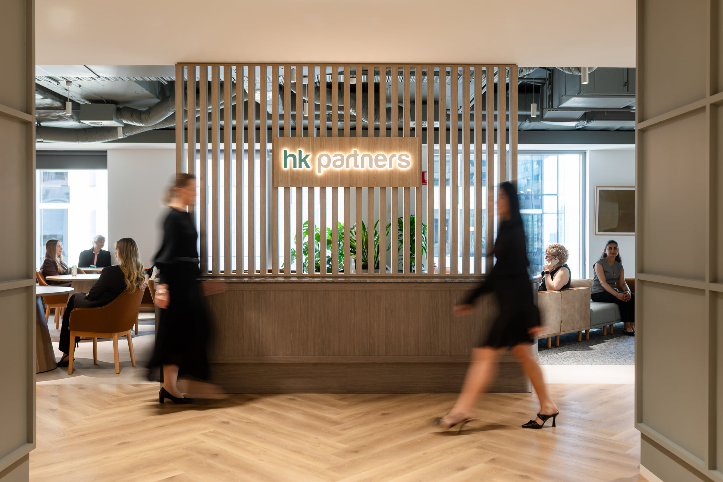 People moving through the HK Partners reception area
