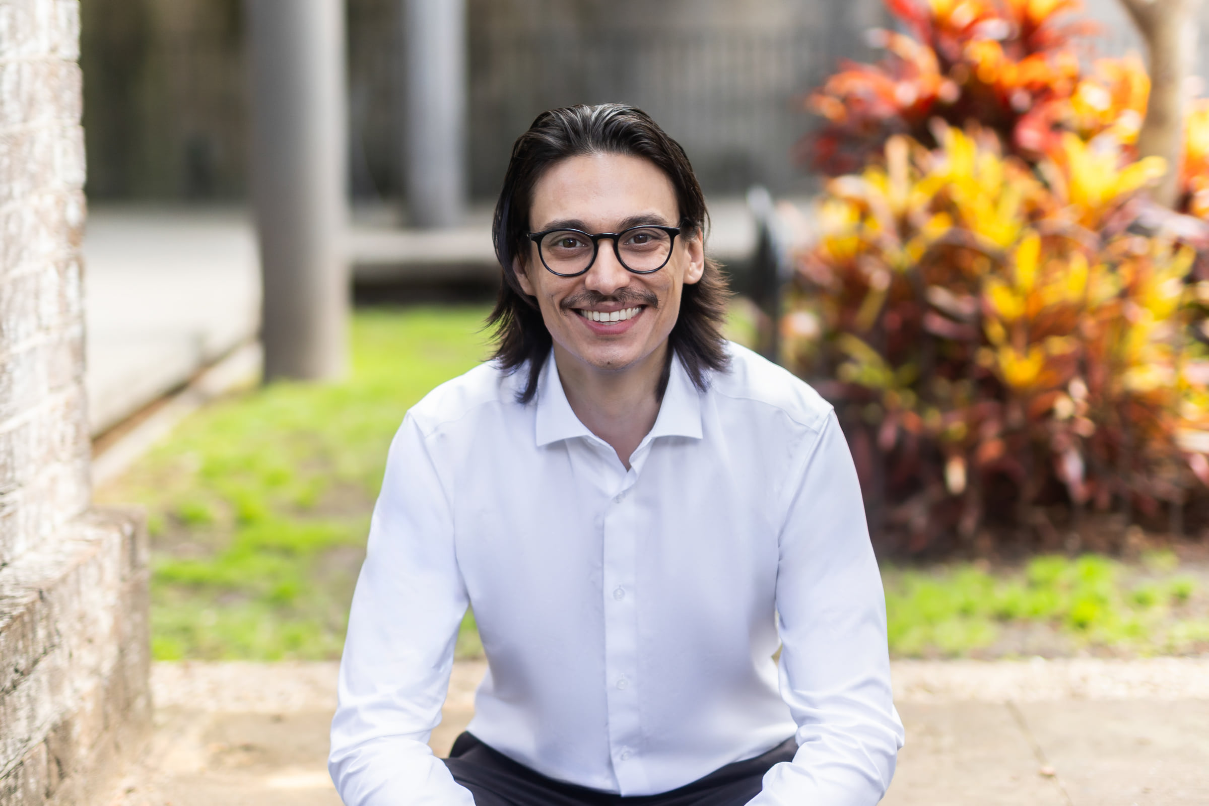 Relaxed outdoor portrait of Bruce Klaic seated in a Sydney garden setting