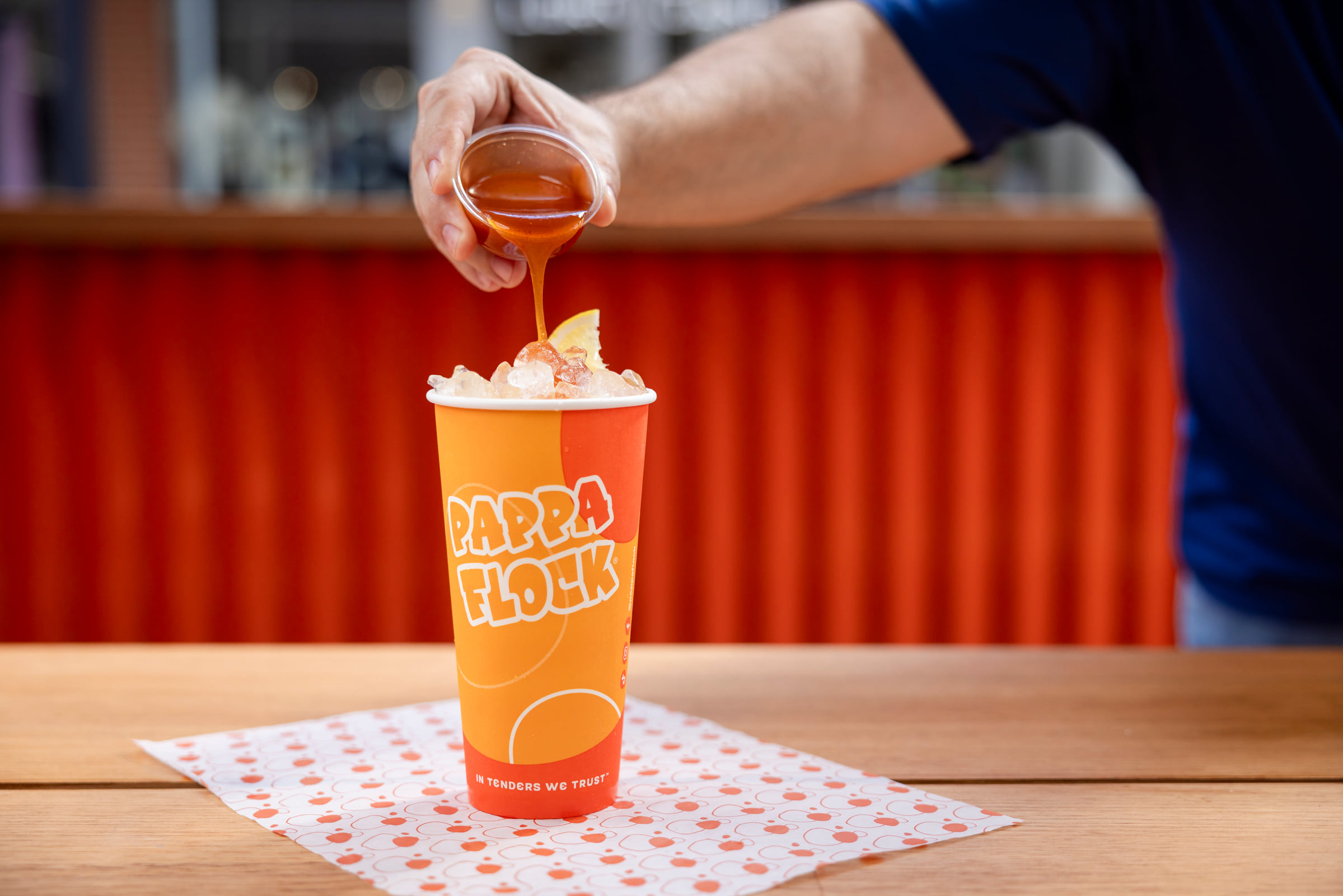 Branded Pappa Flock drink as sauce is poured over ice and a lemon wedge