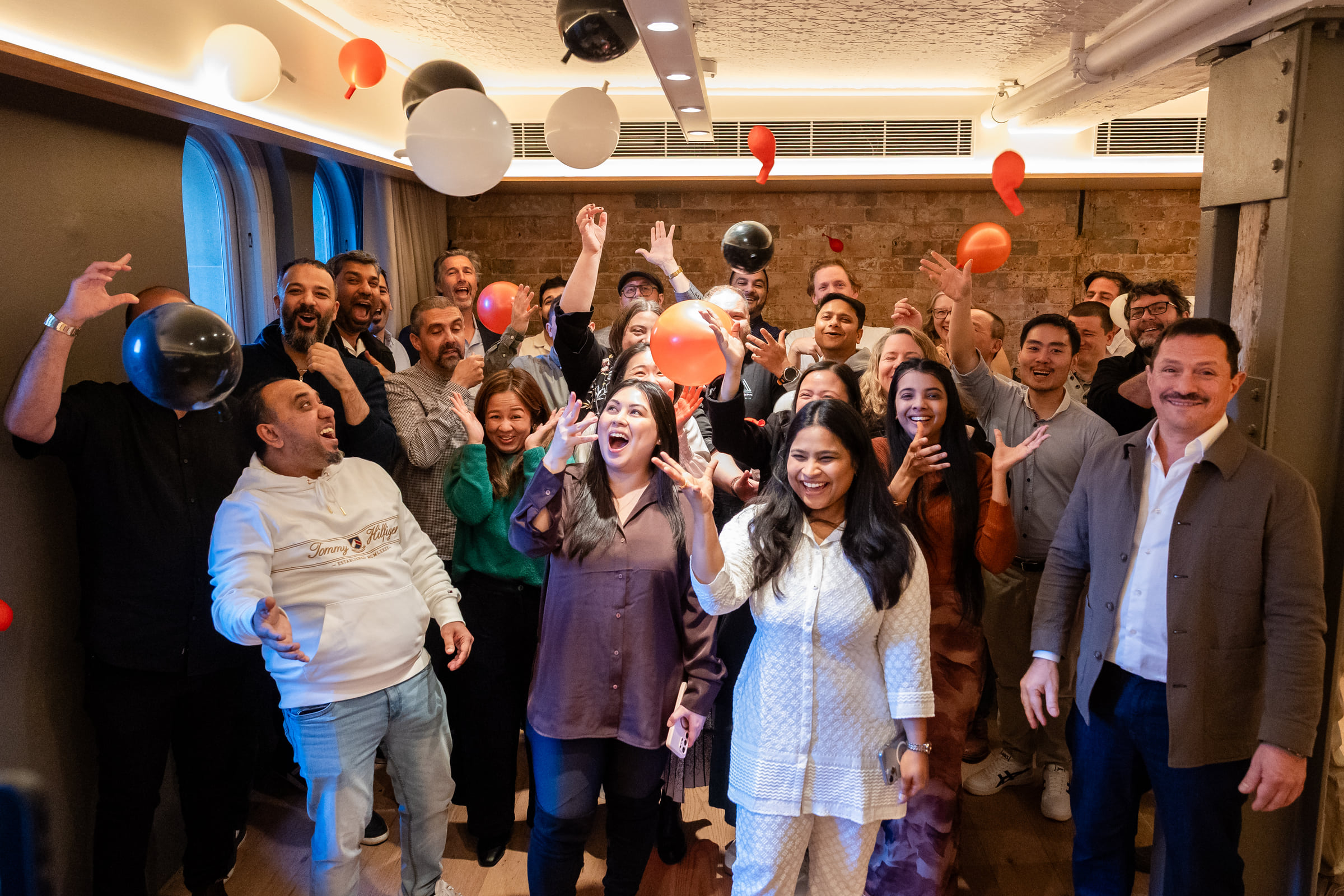 Hubify team laughing and tossing balloons during their FY26 kickoff at Porter House Sydney